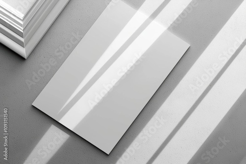 Empty white vertical rectangle poster or business card mockups with diagonal window shadow on the gray concrete wall