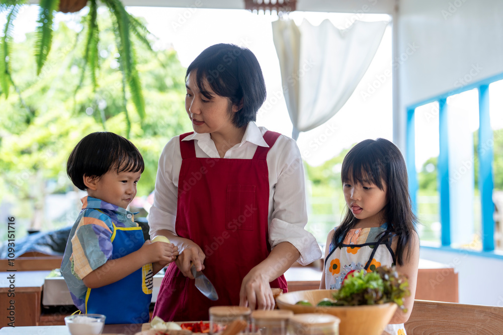 Asian family cooking together in kitchen wearing aprons Asian family cooking together in kitchen wearing aprons