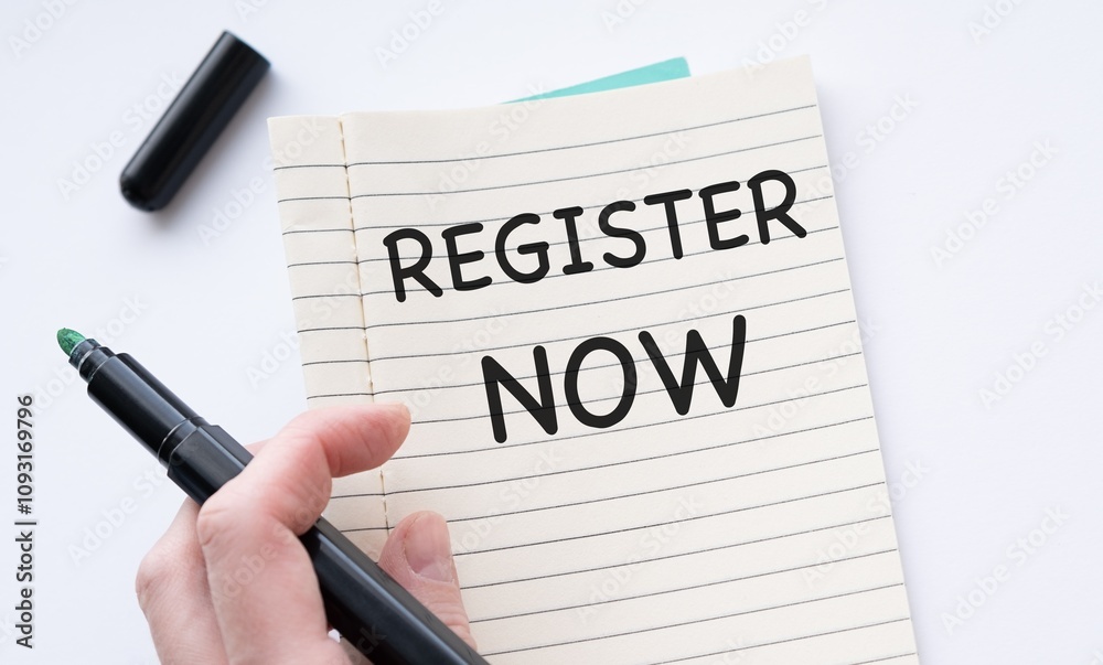 Close-up of a black pen on an open notebook, featuring the text REGISTER NOW for enrollment Close-up of a black pen on an open notebook, featuring the text REGISTER NOW for enrollment