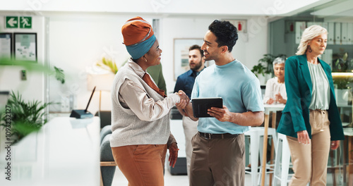 Tablet, happy team and business people shaking hands for collaboration, thank you or support in creative startup. Technology, partnership and handshake for project funding, sponsorship or agreement