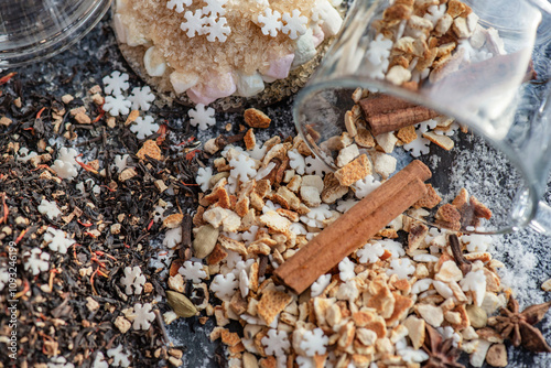 top view on heap of winter hot drink ingredient spilled on table with stick of cinnamon  and sugar star shape photo