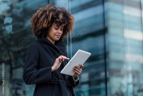 young African American business woman using digital tablet in city of Spain Europe, financial and caribbean people with skyscraper background