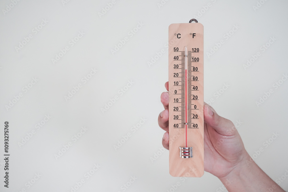 Hand holding classic room thermometer for checking temperature on white background isolation Hand holding classic room thermometer for checking temperature on white background isolation