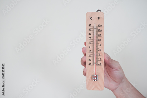 Hand holding classic room thermometer for checking temperature on white background isolation