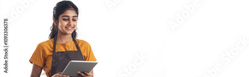 a young indian woman in an apron is holding a tablet while smiling on white background