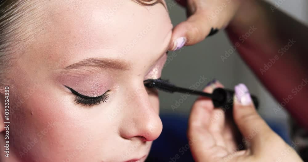 stylist creates eyeshadow on the eyelids of a teenage girl. Stylish make-up stylist creates eyeshadow on the eyelids of a teenage girl. Stylish make-up