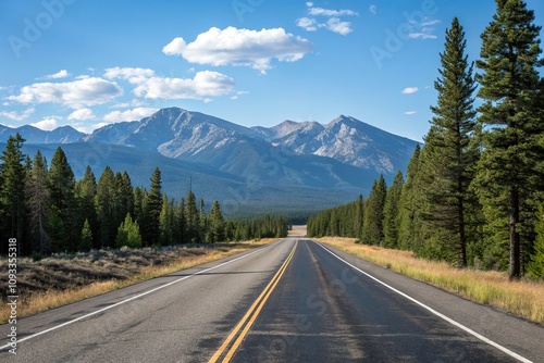 Empty stretch of asphalt road running parallel to a mountain range with a clear blue sky above and pine trees in the foreground, peaceful scene, calmness, road to nowhere