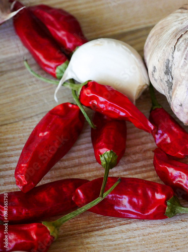 Cooking background. Fresh aromatics laying on a wooden board. Fresh garlic and dried Cayenne peppers. Close-up photography. photo