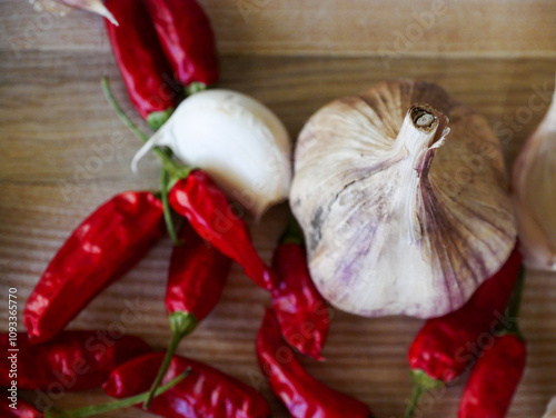 Cooking background. Fresh aromatics laying on a wooden board. Fresh garlic and dried Cayenne peppers. Close-up photography. photo