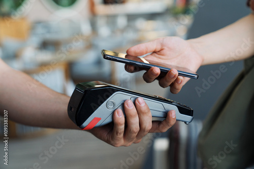 A person is paying for something with a credit card and a phone