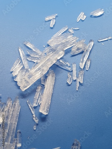 Menthol-crystals with light blue background reflecting in light, looking like frozen ice crystals