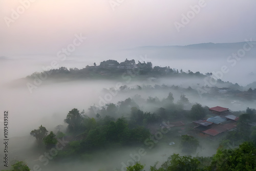 Fog is covering the valley at dawn, creating a mystical atmosphere around the village