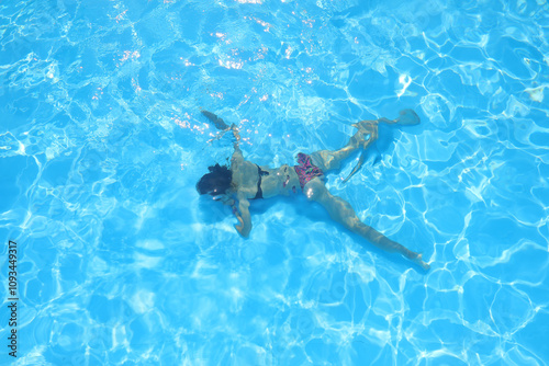 Wallpaper Mural girl lying motionless at the bottom of a blue water pool Torontodigital.ca