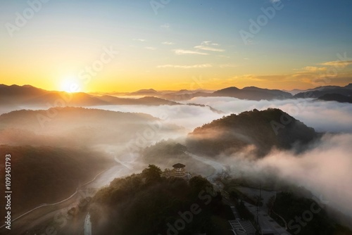 Breathtaking sunrise over a misty mountain landscape with rolling hills and a serene atmosphere