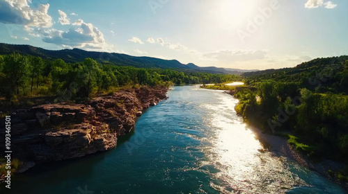 A serene river flows through lush green landscapes under a bright sun, reflecting light on the water's surface, surrounded by rocky hills and distant mountains.