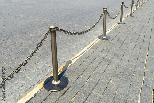 Border of old and modern stone tiles on Red Square in Moscow. Fence posts on pedestrian paths. Sidewalk