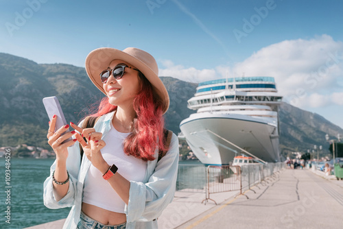 Tourist using smartphone near cruise ship in Montenegro
