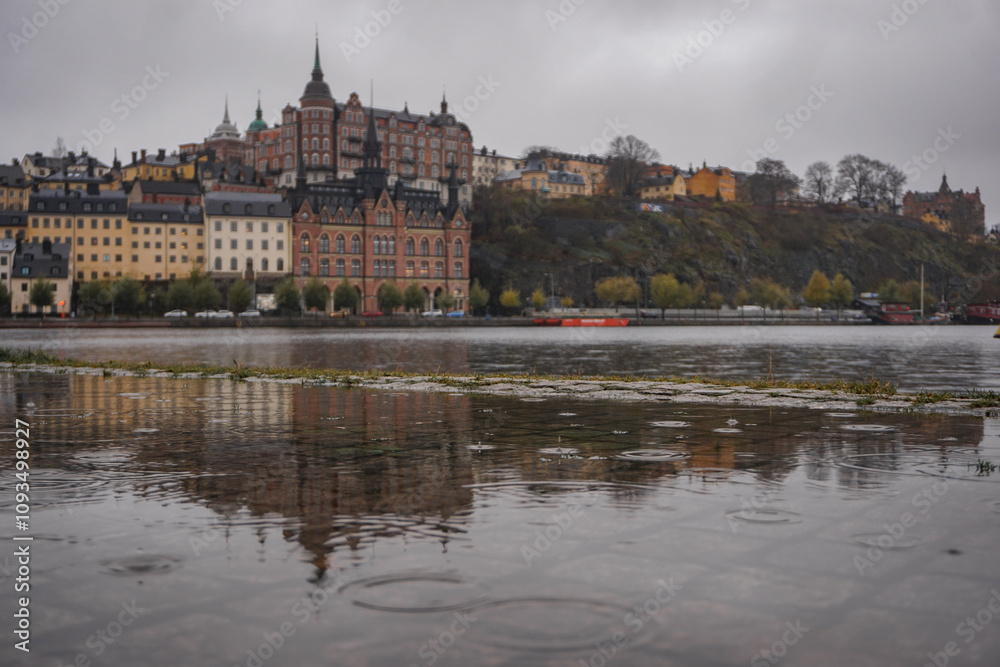 Naklejka premium Buildings by river during rainy day