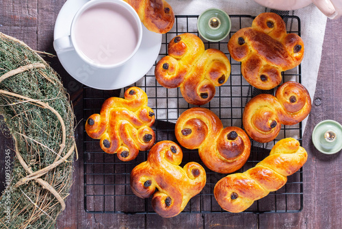 Obraz na płótnie Traditional saffron Swedish buns lussekatt in different shapes, served with cocoa on a wooden table. Buns for St. Lucia's Day. w salonie