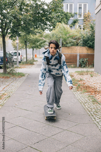 Girl student with headphones, commuting on a skateboard in a modern city setting