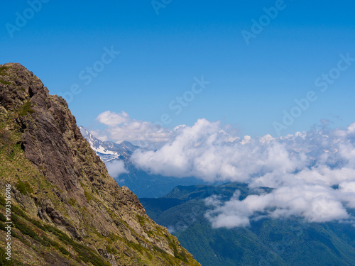 Majestic mountain peaks capped with snow and washed by clouds create a breathtaking wilderness landscape photo