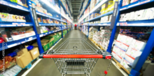 Foto Pusty koszyk, wózek sklepowy w supermarkecie, rozmazane tło, wnętrze sklepu, supermarketu, wózek na zakupy, półki sklepowe z produktami