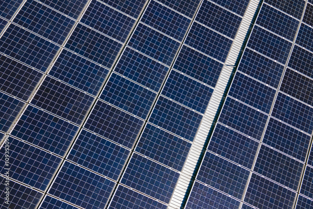 Office building with solar roof. Blue photovoltaic panels for producing clean ecological electric energy. Investing in renewable electricity concept