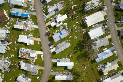 Severely damaged houses after hurricane Ian in Florida mobile home residential area. Consequences of natural disaster photo