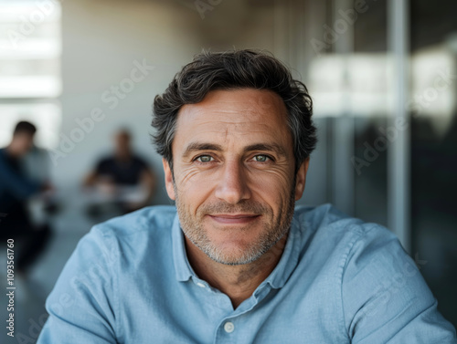 Friendly man smiling warmly in a bright, professional setting 