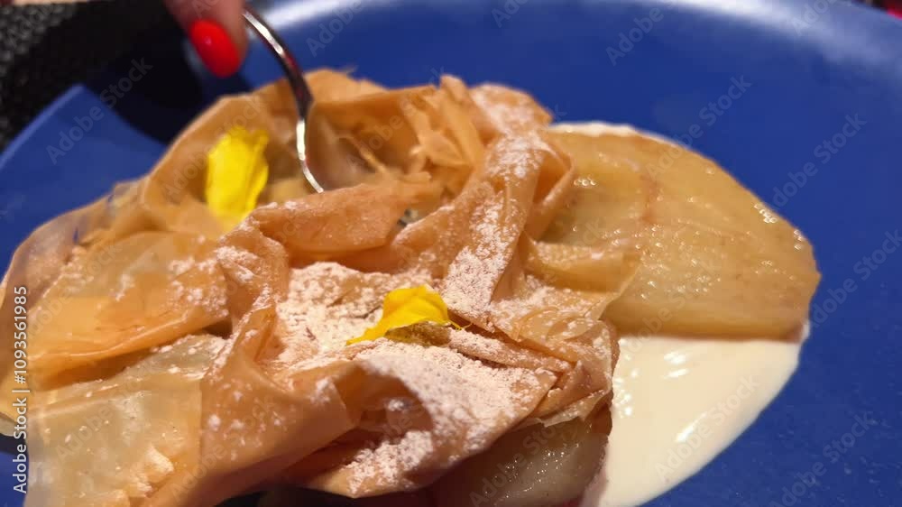 puff pastry cake with pear in cream sauce sprinkled with powdered sugar restaurant serving on a blue plate puff pastry cake with pear in cream sauce sprinkled with powdered sugar restaurant serving on a blue plate