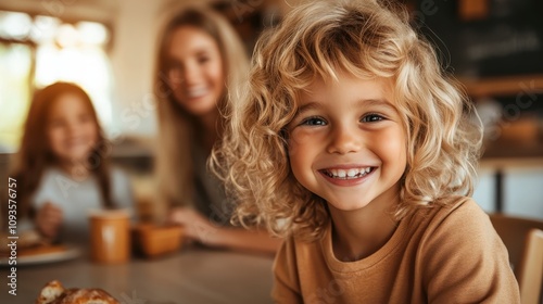 A joyful child with curly blonde hair smiles warmly at the camera in a cozy environment, exuding happiness and warmth, set in a family-friendly atmosphere.