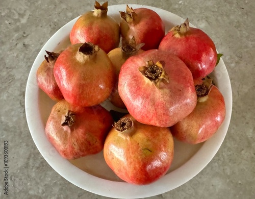 Obraz na płótnie Fresh and organic pomegranates were displayed in a white bowl w salonie