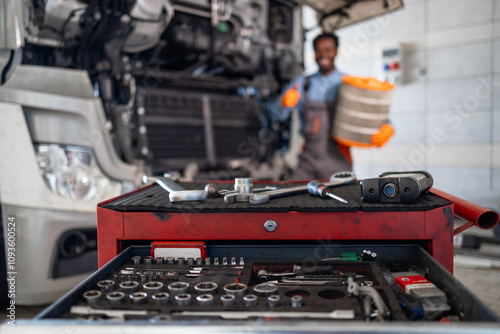 Truck service and maintenance. Focus on tool box and trucks being serviced in background. photo