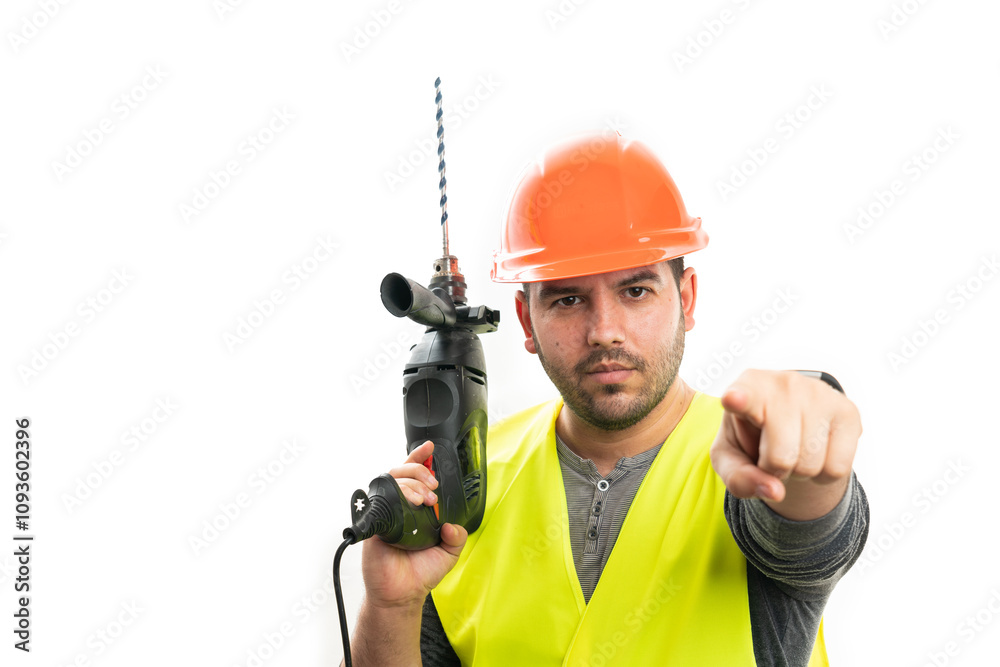 Construction worker holding powertool drill pointing index finger Construction worker holding powertool drill pointing index finger
