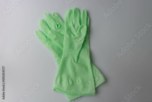 Two light green rubber gloves are lying on the table.