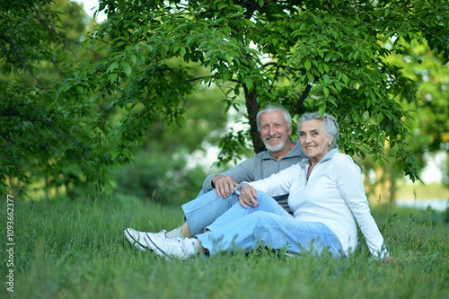 Portrait of senior couple sitting on the grass in the park