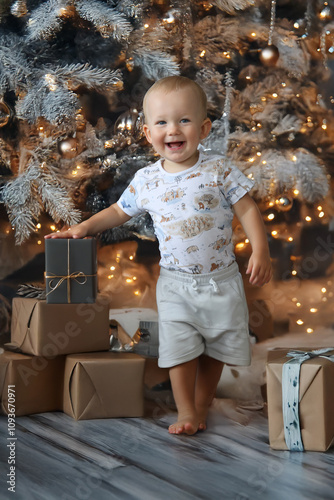 Christmas, a little boy with a Christmas tree and lots of unwrapped presents. Christmas atmosphere in the comfort of home.