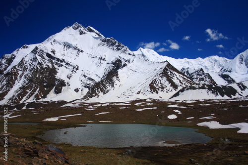 snow on mountain peaks feeding the lake down the hill after melting in summer