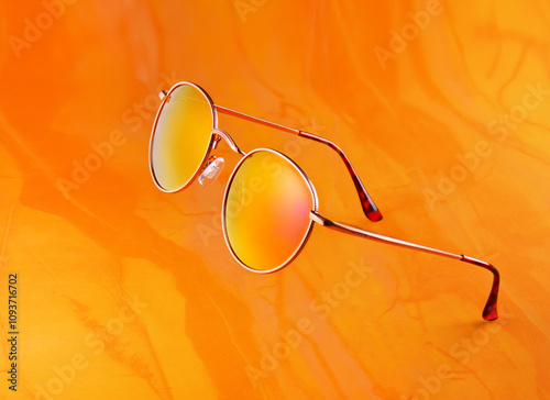 Stylish Yellow Tinted Sunglasses Set Against a Vibrant Orange Background for a Dazzling Look