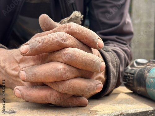 Foto closeup of clasped rough dirty  hands of elderly hard working carpenter over woo