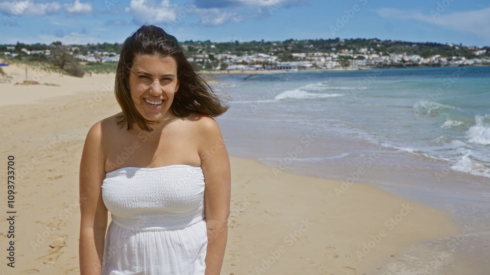 A young, beautiful hispanic woman smiles on the sandy beach of pescoluse, italy, with bright blue skies and the peaceful salento seascape in the background, enjoying the serene puglia coast. A young, beautiful hispanic woman smiles on the sandy beach of pescoluse, italy, with bright blue skies and the peaceful salento seascape in the background, enjoying the serene puglia coast.