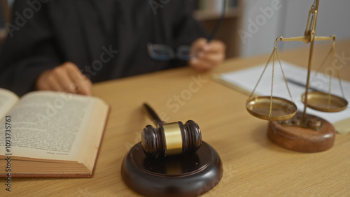 Εκτύπωση καμβά Judge reading book with gavel and scales on desk, hands visible operating in an indoor court setting