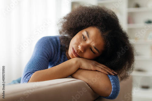 Seasonal Depression. Upset Young Black Woman Sitting On sofa At Home And Looking Aside, Sad Pensive African American Female Suffering Life Problems Or Mental Breakdown, Feeling Lonely, Copy Space