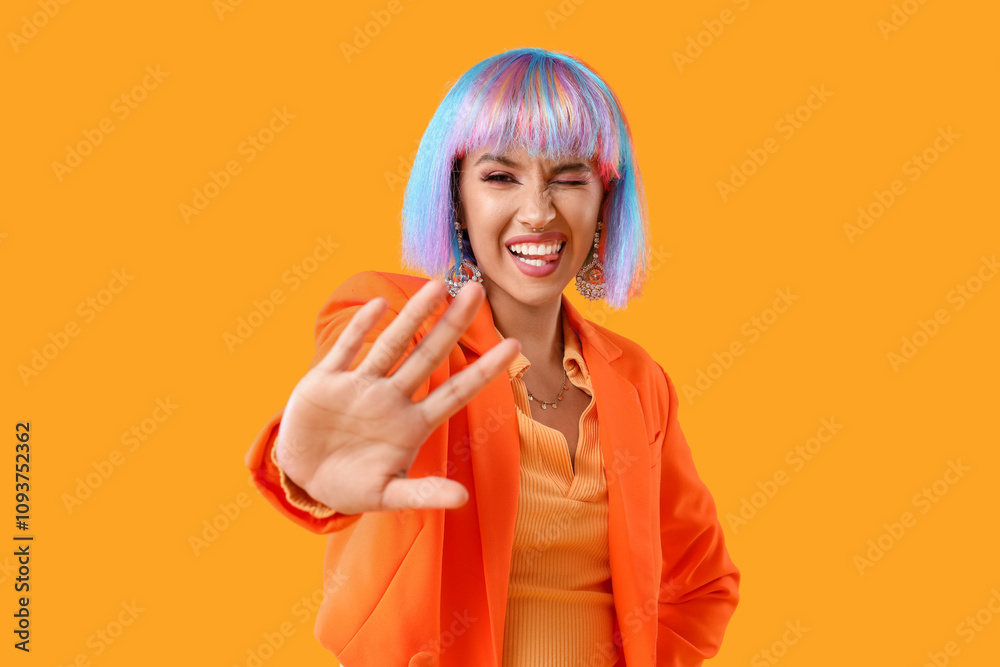 Beautiful young happy woman in colorful wig on yellow background Beautiful young happy woman in colorful wig on yellow background