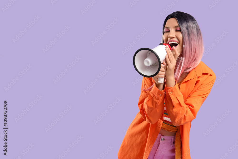 Beautiful young happy woman in pink wig with megaphone on purple background Beautiful young happy woman in pink wig with megaphone on purple background