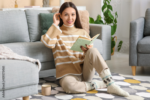 Young woman reading book on...