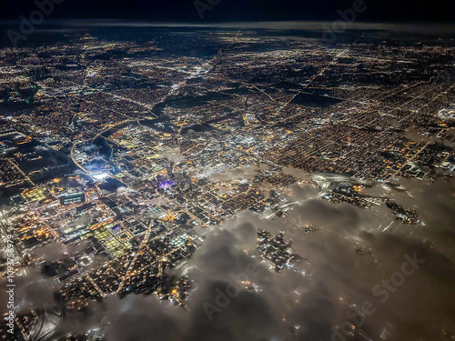 Aerial View Of City Lights At Night Through Clouds