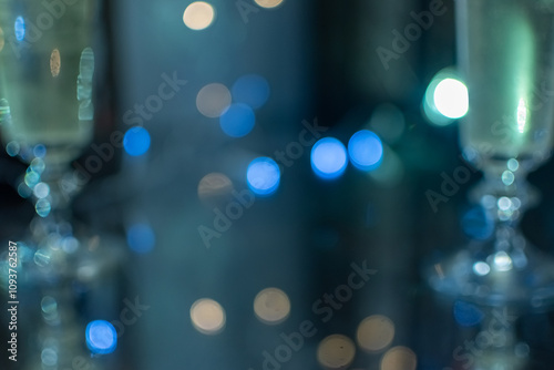 Defocused blurred image of Сhampagne glasses close-up on blurred festive background with multicolored lights