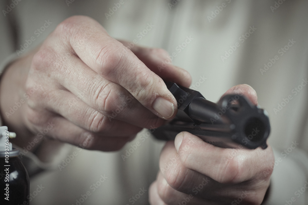 Obraz premium Man take care of semi automatic pistol handgun at home