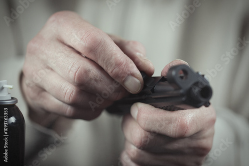 Man take care of semi automatic pistol handgun at home photo